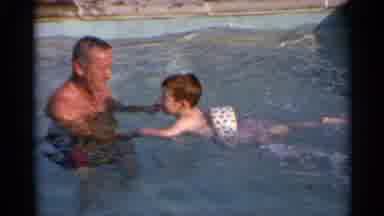US Virgin Islands (1966): Caucasian Man Smiles As He Teaches His Son The Basics Of