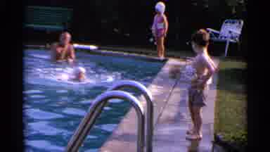 US Virgin Islands (1966): Two Kids With Their Floats On Are Standing Poolside And