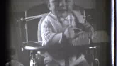 Danielson Connecticut (1939): Baby Sits In Highchair With Object Smiling And