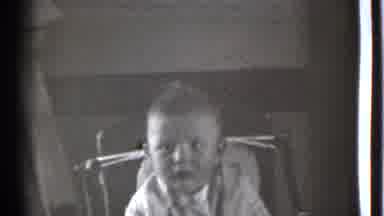 Danielson Connecticut (1939): Black And White Baby Sitting In A Chair Playing With