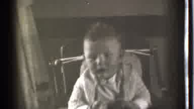 Danielson Connecticut (1939): A Small Child Wearing A Warm Jackets Sits Alone In A