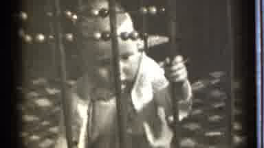 Danielson Connecticut (1939): Toddler Wearing White Sweater Looking Through Metal