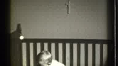 Danielson Connecticut (1939): A Young Child Sits In A Crib There Is A Cross