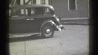 New York (1939): Person Wearing Black Cot Walks Towards Irked Black Car