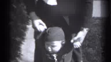 New York (1939): Man Helps Toddler Walk Down Sidewalk While Woman Walks Outside