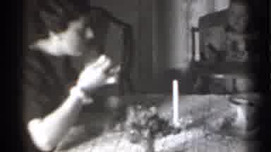 New York-1939: Woman in Black Dress Eats While Watching Baby in High Chair