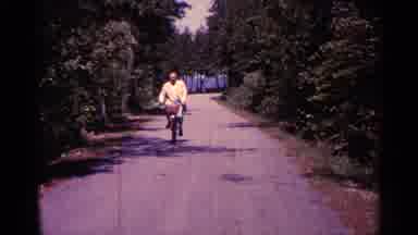 Michigan USA (1960): Old Man Enjoys His Bicycle Ride And Moves In Rod