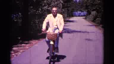 Michigan USA (1960): Man In Yellow Cot Riding His Bike Towards Comer