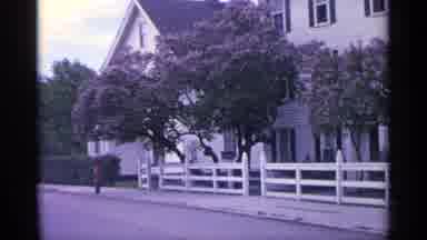 Michigan USA (1960): White Three Stepmother Building Sits Behind White Picket