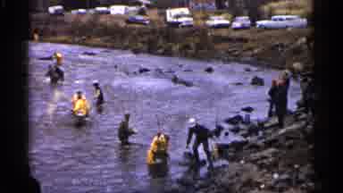 Minnesota USA-1961: People In Yellow And Grey Fishing With Nets In Shallow River
