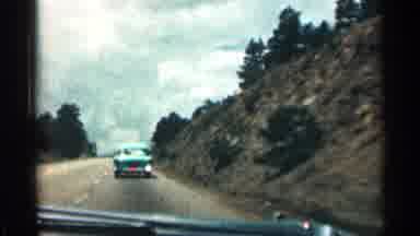 Colorado USA (1963): Riding Inside Car Down Highway Lined With Trees Rocks And