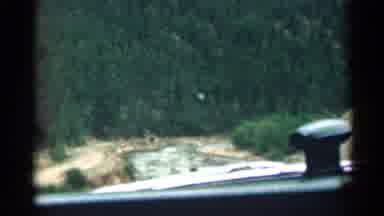 Colorado USA (1963): Car Driving Through Rod Surrounded With Mountains And Trees