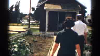 Colorado USA (1963): Mourn Couple Entering House Of Worshiper On Windy Day While