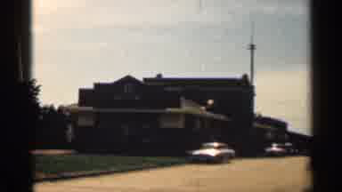 Texas USA (1963): Building That Sits On Side Of Street With Cars Irked Long It