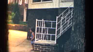 Texas USA (1963): Bottom Of Stairway Girl In Blue Dress Swings Jump Rope