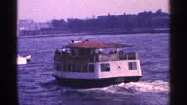 New York City (1964): Boats Traveling On Body Of Water And Statue Of Liberty In