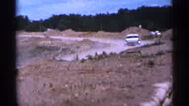 Duluth Minnesota (1965): White Car Travels Down Dirt Pt On Bright Sunny Day
