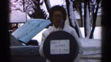Georgia USA (1966): Person Wearing White Cot And Black Glasses Holds White Back