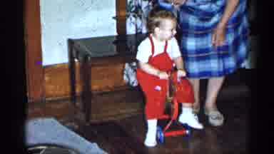 New York-1955: Grandma Pushing Child On Push Toy