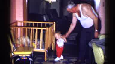 New York (1955): Man Holds Hand Of Toddler Just Learning How To Walk Cross
