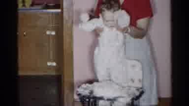 New York (1955): Woman Wearing Red Shirt Helps Baby Sand In White High Chair