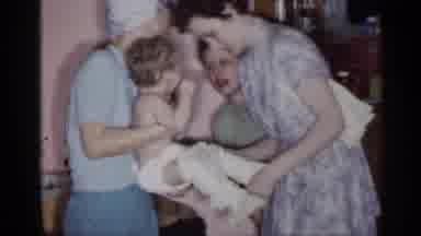 New York (1955): Woman Wearing Blue Shirt Hold Varying Infant While Others Dress