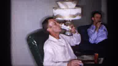 New York (1955): One Man Drinks Beer In Rocking Chair While Other Smokes Cigarette
