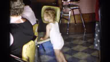 New York (1955): Toddler Wearing White Shirted Shooter Walks To Green Dining Chair