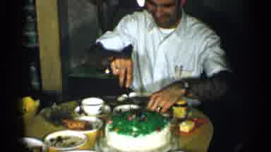 New York (1955): Man Wearing White Shirt Cuts White And Green Holiday Cake