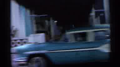 Florida (1958): Car Is Driving Through City With Lots Of Buildings With Lots Of