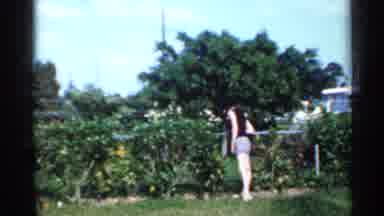 Florida (1958): Boy Wearing White Shirt Runs Cross Grass While Kids Swing Dockyard