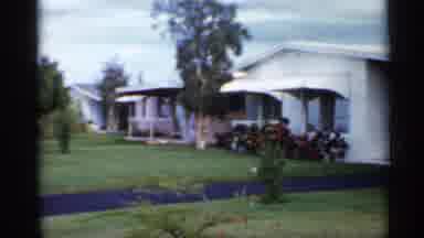 Florida (1958): Woman Wearing Green Dress Carries Paper B Into House On Cleo Day
