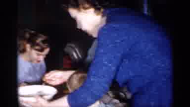 New Jersey (1958): Woman Wearing Blue Dress Serves Food To People Meted At Table