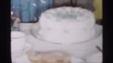 New Jersey (1958): Woman Wearing Blue Dress Cuts White Cake While Toddler Stands