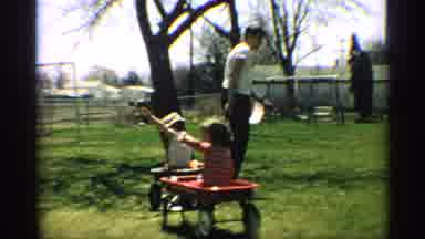 Arizona (1959): Guy Pulling Young Boy And Girl That Are Waving In Wagons In