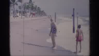 California (1959): Woman And Child Standing In Eves At Sandy Beach
