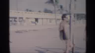 California (1959): Man Wearing White Shirt Watches People Standing In Sea Surf