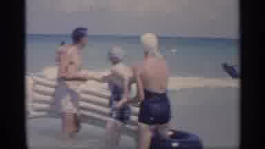 California (1959): Severn People In Swimsuits With Flotation Ids In Water Breaking