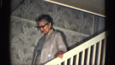 California (1959): Elderly Woman Walking Down Stairs While Young Man Is Running