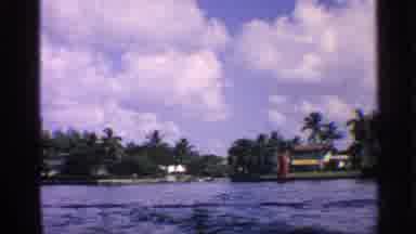California-1959: Waterway With Palm Trees, Houses, and Blue Sky