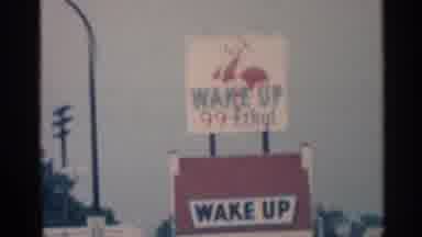 Indiana (1959): Passing Brown Building And Red And White Wake Up Sign