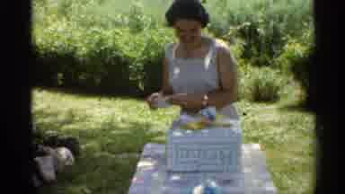 Indiana (1959): Woman Standing Outside At Table With Present On It Opening Up A