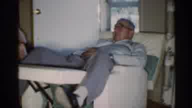 Indiana (1959): Woman Wearing Yellow Dress Sits In Wooden Chair Talking To Man