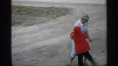 Indiana (1959): Older Woman Playing On Dirt Rod With Child In Red Cot