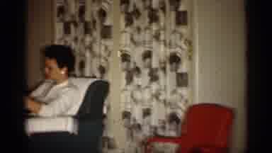 Indiana (1959): Woman Wearing White Sweater And Blue Skirt Sits In Living Room