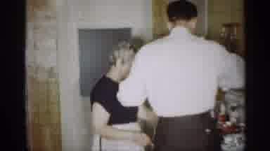 Indiana (1959): Man Helping Women In Kitchen Cooking Dinner While Kid Plays