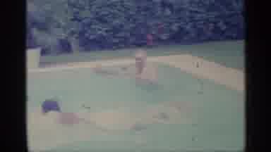 Indiana (1959): Man Wearing White Shooter Swims Across Pool On Sunny Day