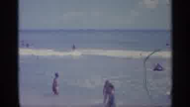 Indiana (1959): People Swimming In Ocean And A People Hanging Out By Shore