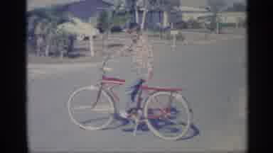 Indiana (1959): Boy Wearing Green Ants Sits On Red And Yellow Bicycle On Cleo Day