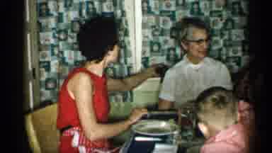 Michigan (1959): Family Passing Food Round Table While Eating Mel